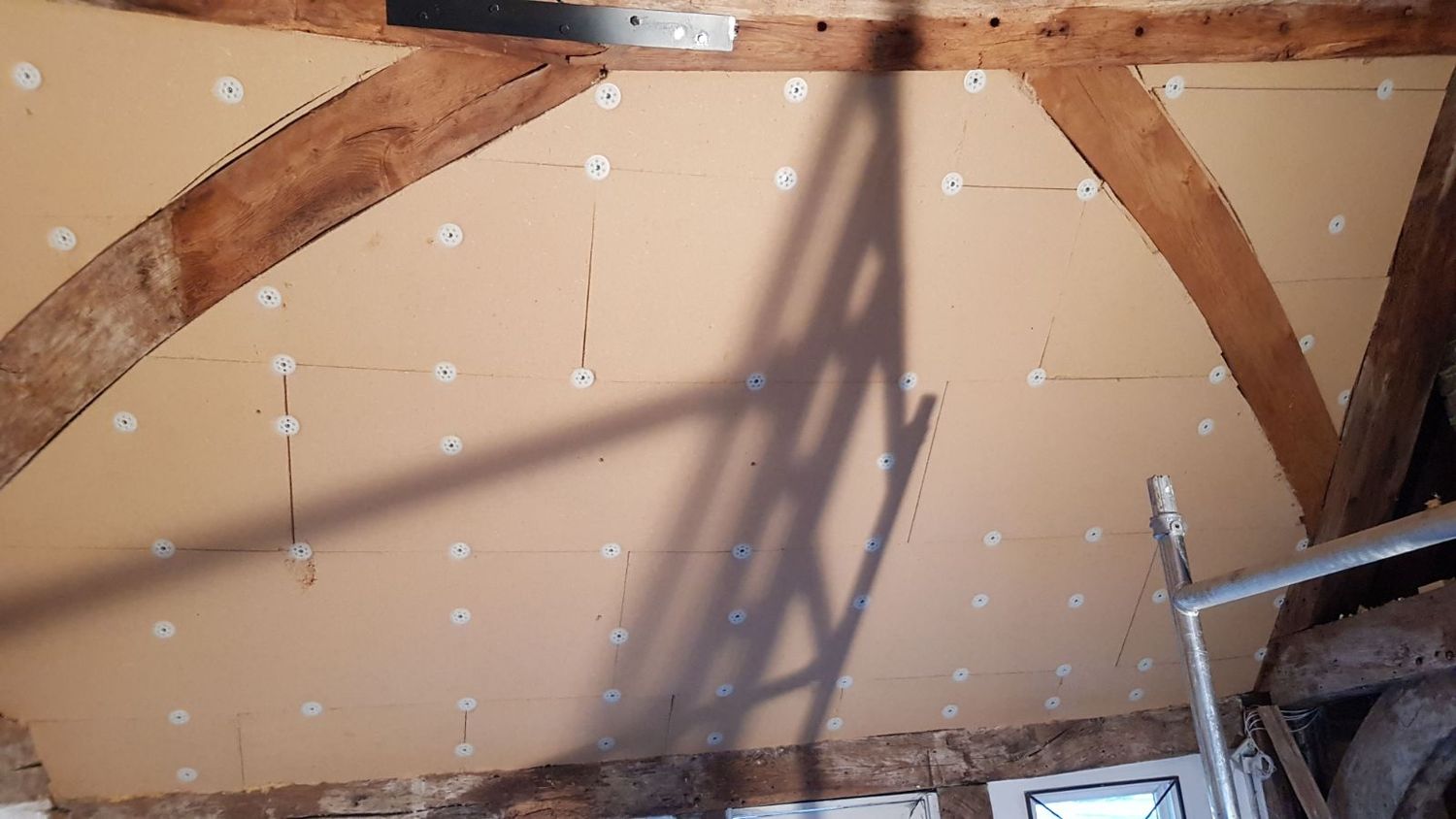 Insulation fitted around the original curved timbers