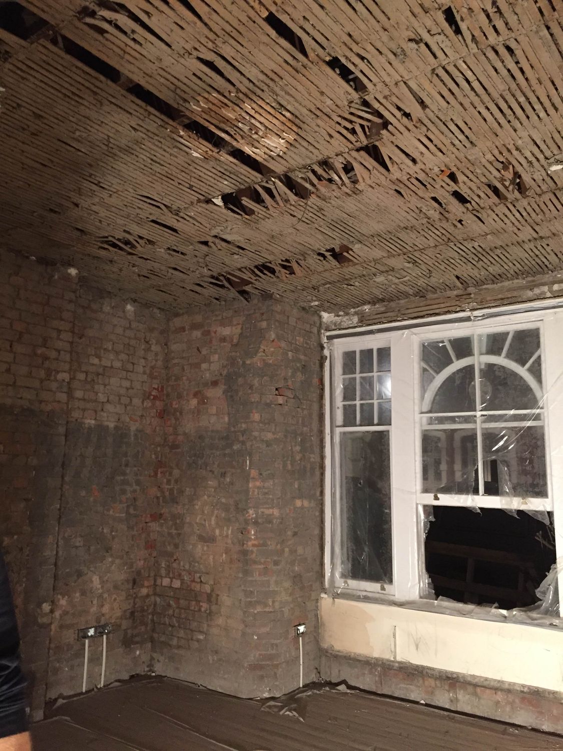 A house mid-renovation, floors up and walls back to masonry