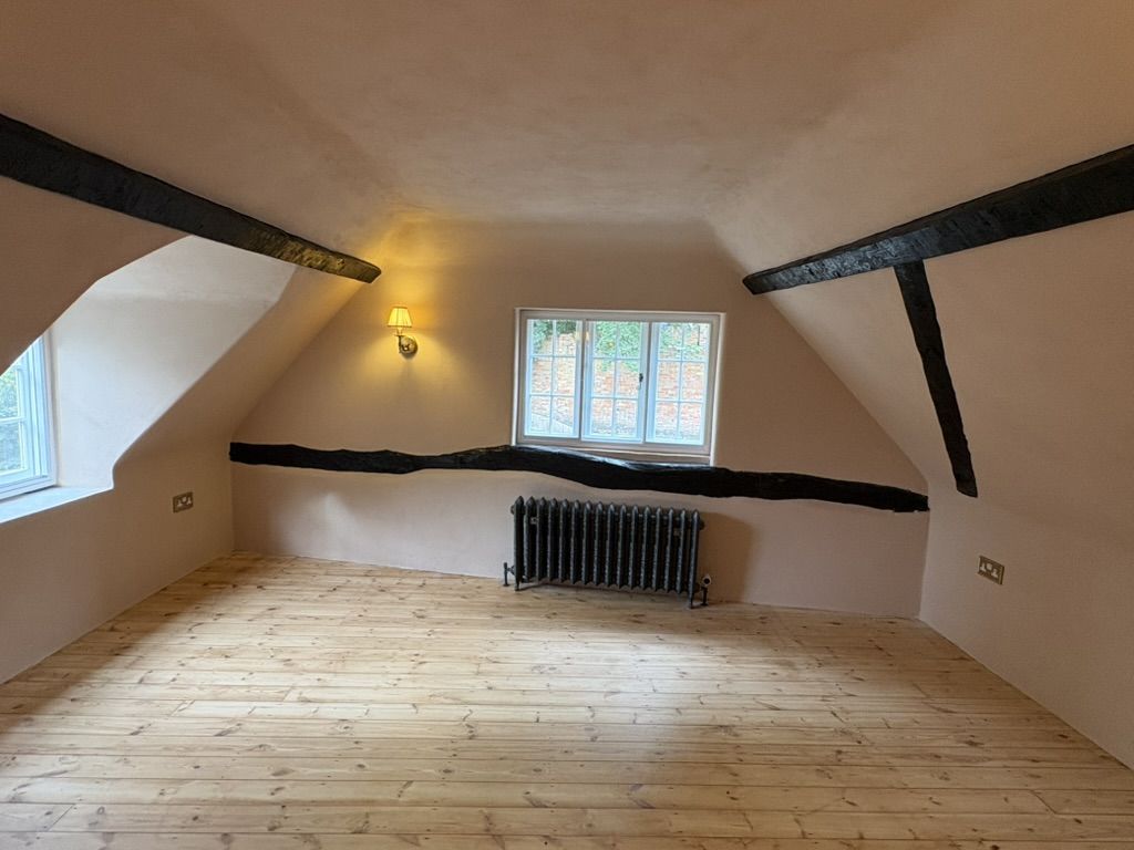 Finished room plastered painted, with exposed timber beams