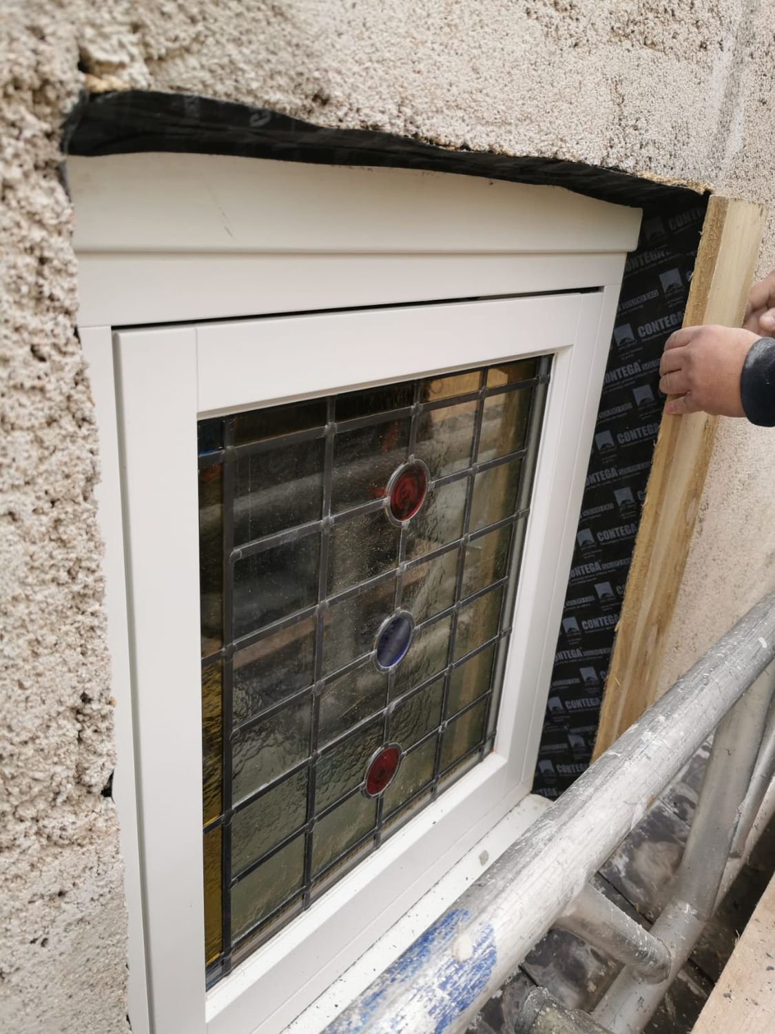 Applying Contega Solido Exo airtightness tapes around external window reveal