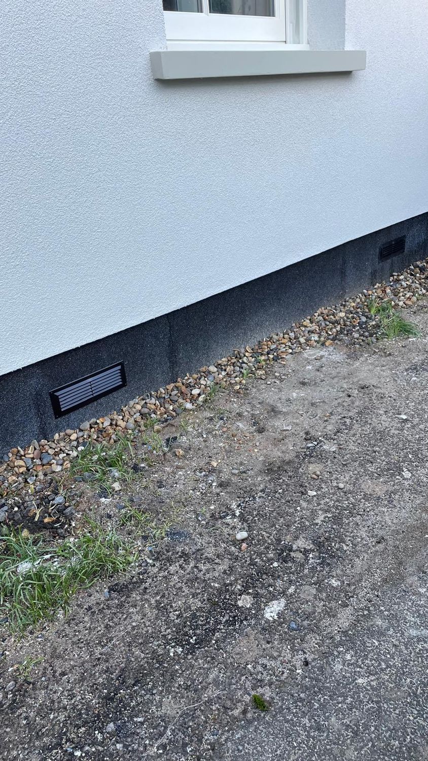Completed plinth insulation with grey Mosaic render and ventilation grilles