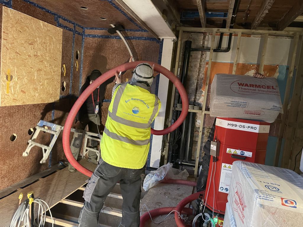 Blowing Warmcel cellulose insulation into walls and ceilings with XFloc machine