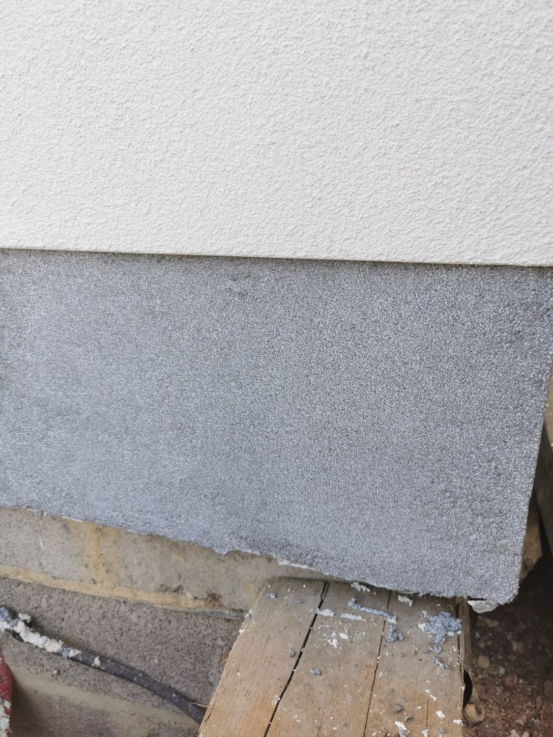 Plinth insulation with grey mosaic render