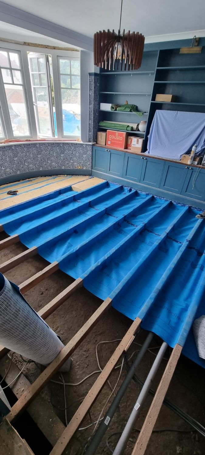 Suspended floor insulation - Pro Clima Solitex Plus breathable membrane being installed over floor joists