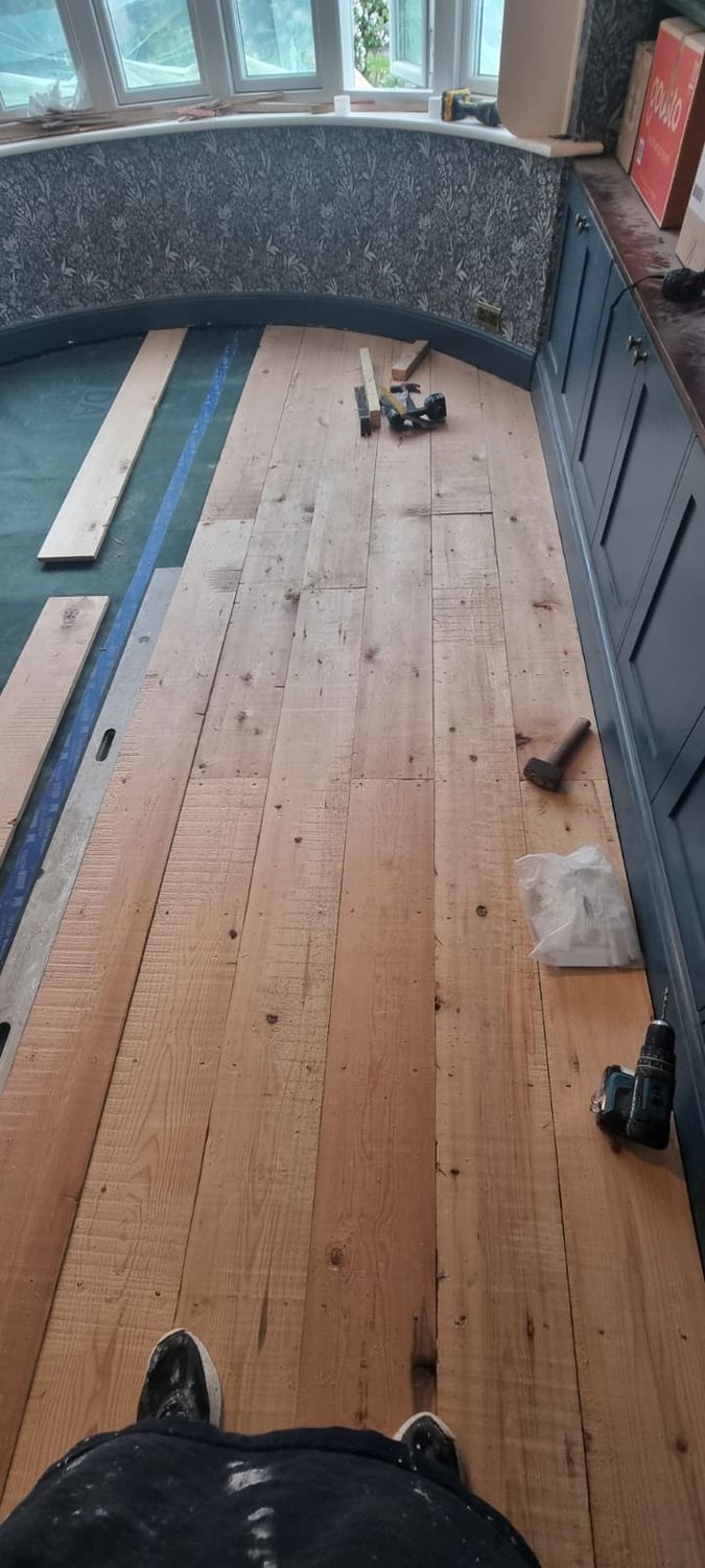 Reclaimed floor boards are installed onto insulated and airtight floor structure