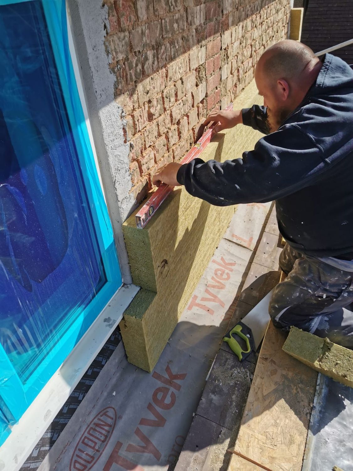 Mineral wool boards being adhered to masonry wall