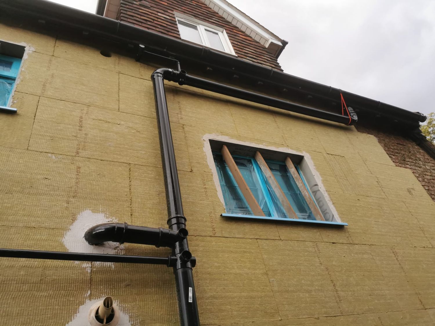 Downpipes being refitted to suit new wall level
