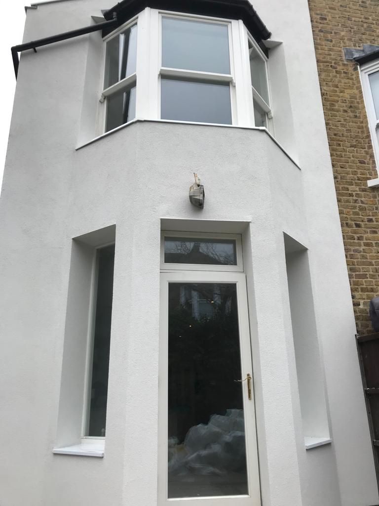 External wall insulation with cork insulation boards installed, aluminium window sills with breathable silicone render