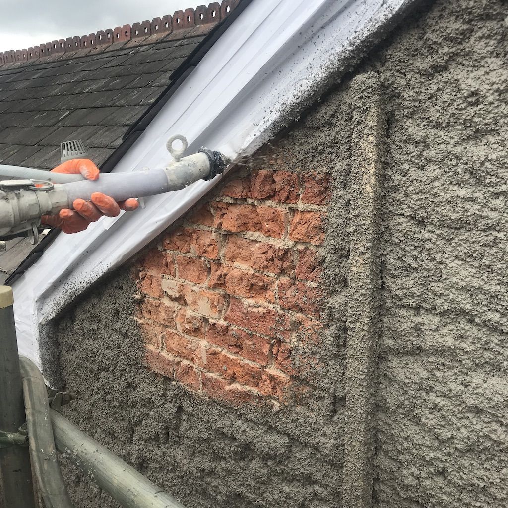 Spraying Diathonite Evolution lime-cork insulating render on spalling brickwork