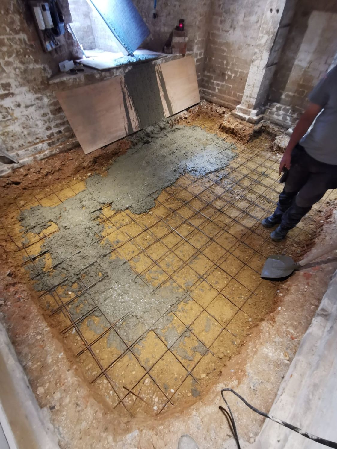 Basement sub floor installation with reinforcing mesh in place