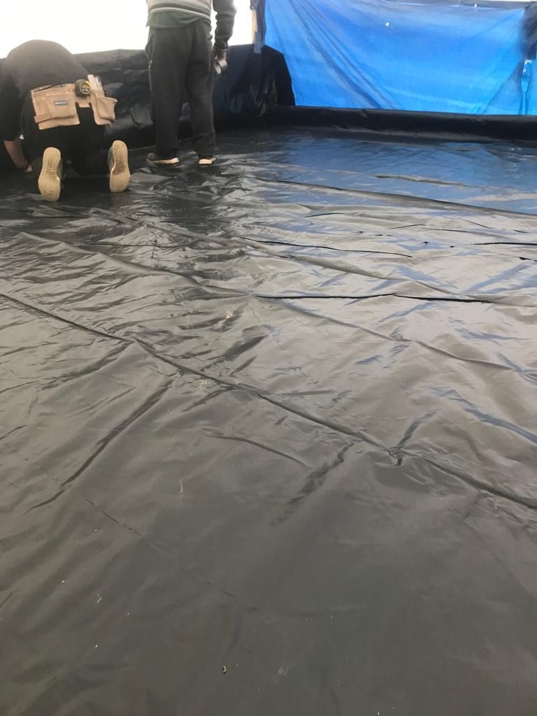 Flat roof structure being constructed, VCL membrane being laid