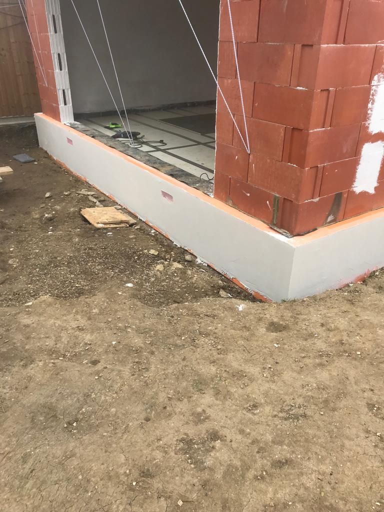 Plinth insulation boards being installed around perimeter of new extension
