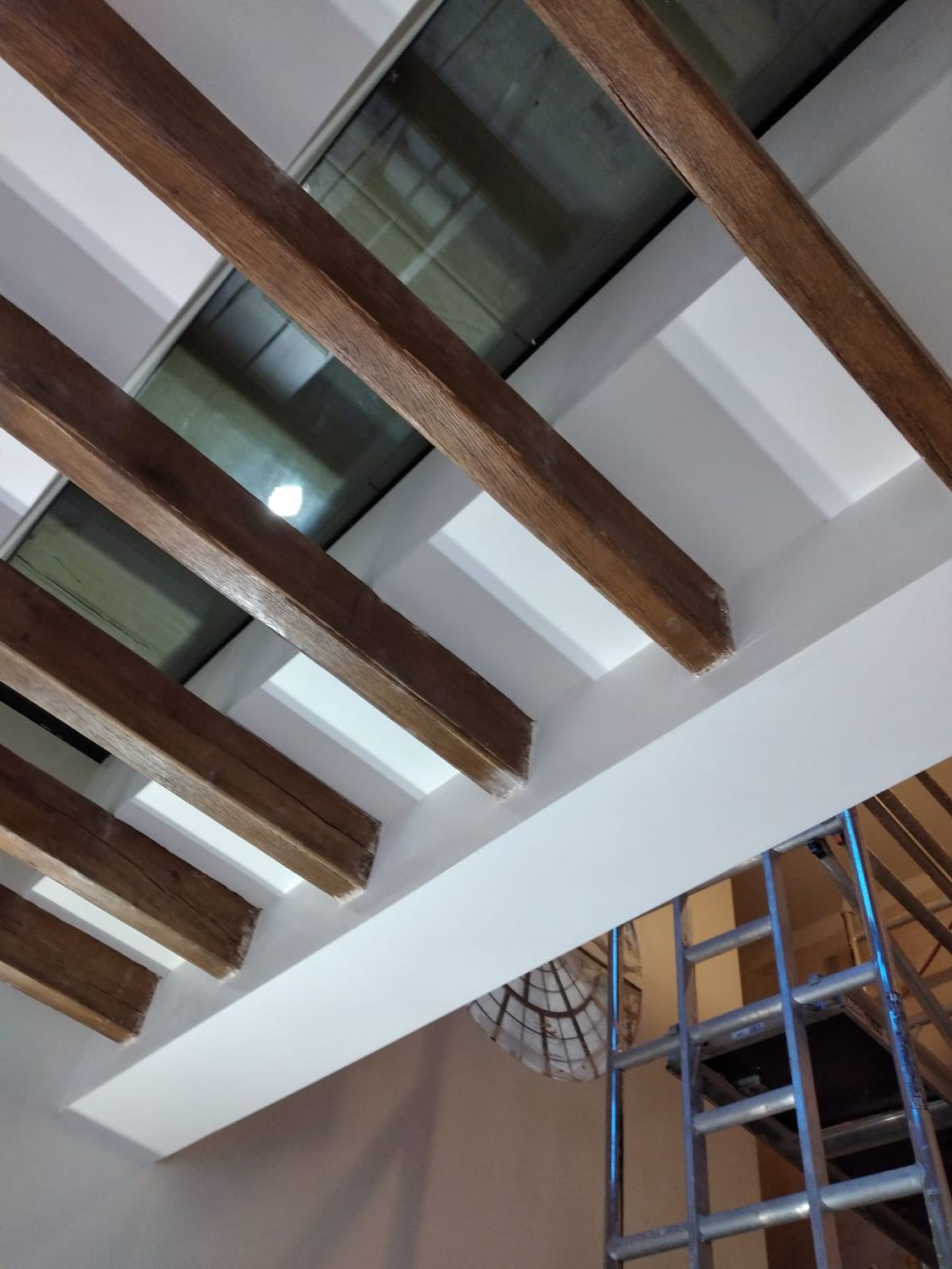 Flat roof with exposed oak ceiling joists and frameless walk-on rooflight for terrace over extension in Archway