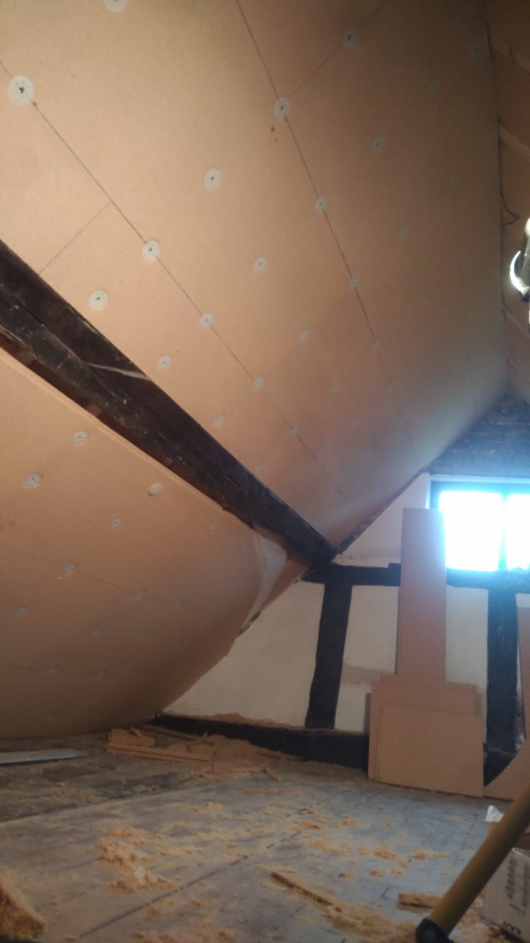Pavatex insulation boards below rafters and exposed beams