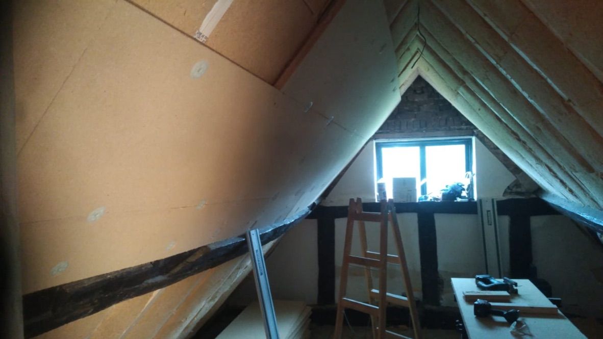 Wood fibre boards being installed underneath rafters